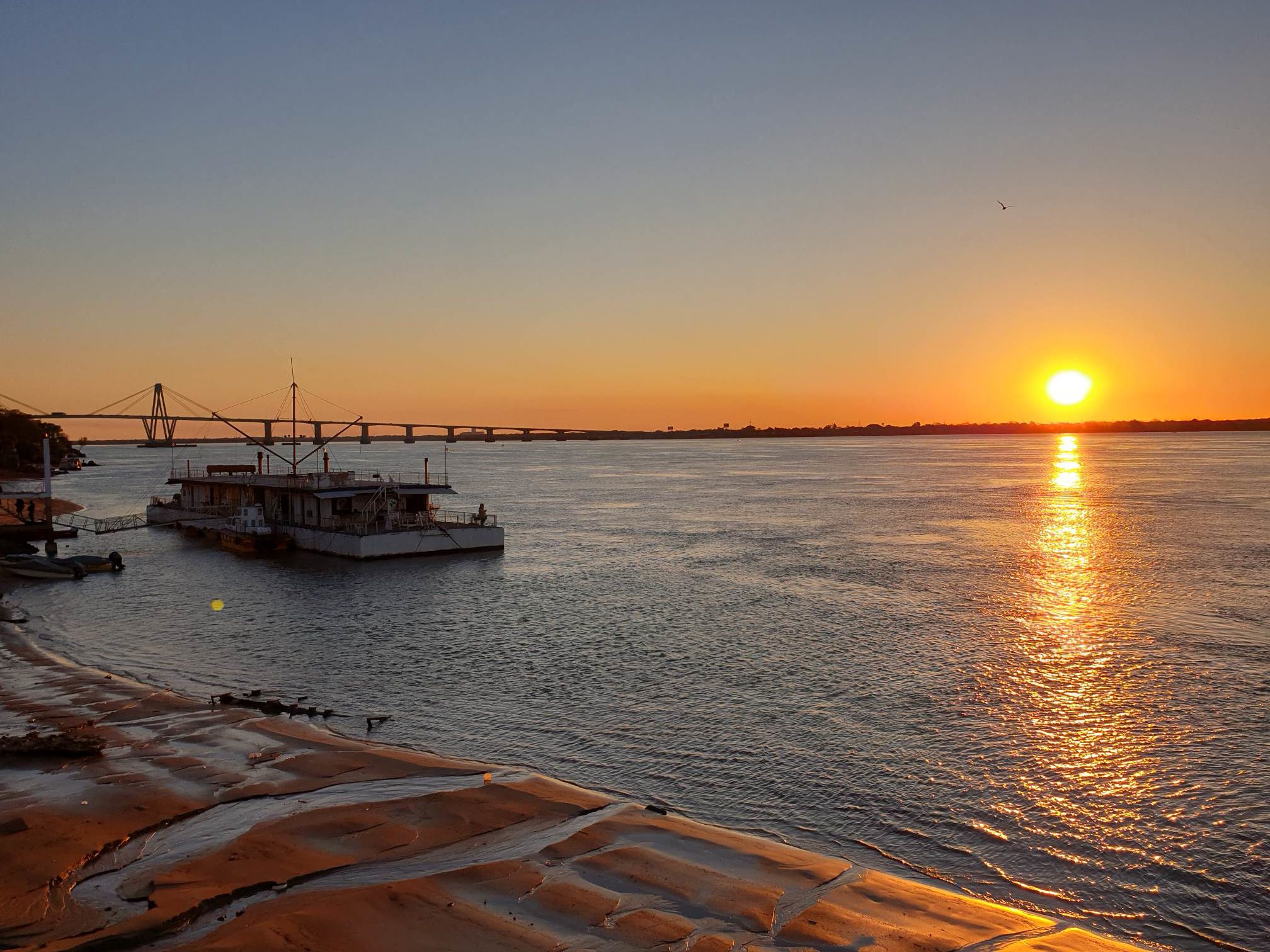 Sonnenuntergang mit Boot und Brücke
